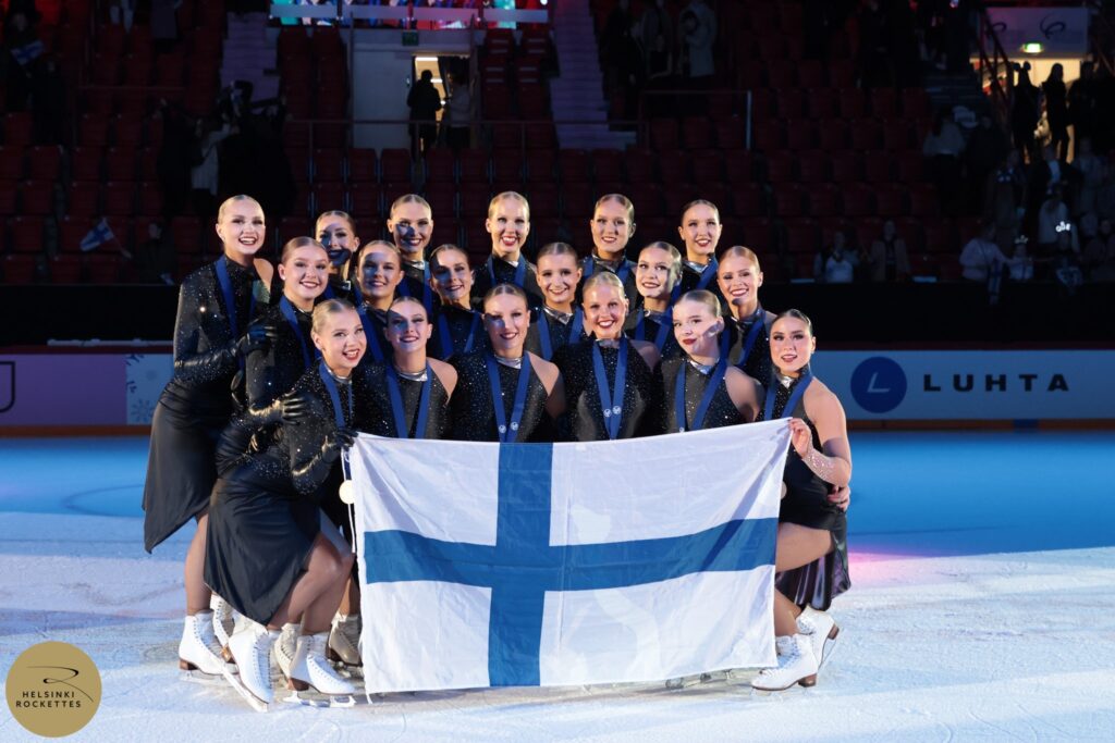 Helsinki Rockettes maailmanmestari 2025 jäällä Suomen lipun kanssa